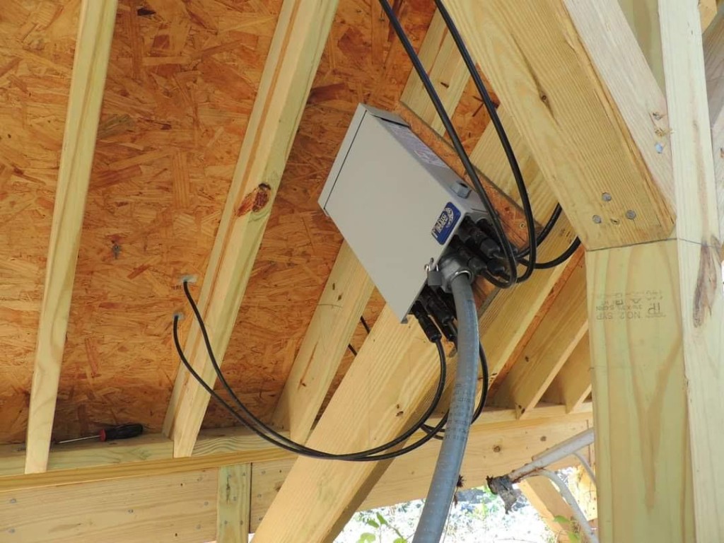 Solar combiner box mounted under roof framing