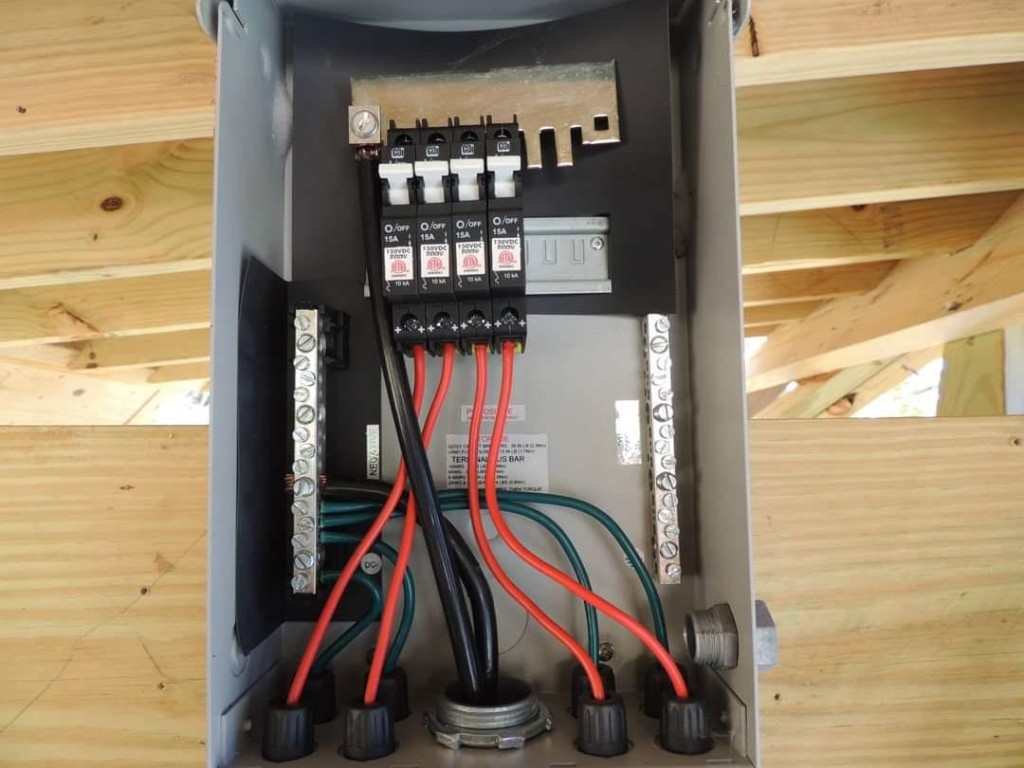 Interior of solar combiner box showing DC breakers and wiring